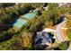 Aerial view showing home, tennis courts, and pool in a wooded community at 5610 Bent Grass Way, Douglasville, GA 30135