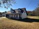 White house with brown roof, covered porch, and attached garage at 1350 Cedars Rd, Lawrenceville, GA 30045