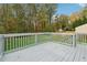 Grey wood deck overlooking a fenced backyard and wooded area at 1277 Muirforest Dr, Stone Mountain, GA 30088