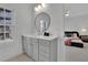 Bathroom with a vanity, round mirror, and gray cabinets at 4814 Moonview Ln, Sugar Hill, GA 30518