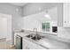 Kitchen with double sink, white cabinets, and view to the living room at 966 Romer Pl, Stone Mountain, GA 30083