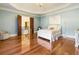 Spacious bedroom with hardwood floors, soft blue walls, and a white bed at 1513 Jones Rd, Roswell, GA 30075