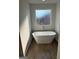Relaxing bathroom with free standing tub and wood-look tile floor at 510 Overlook Rd, Covington, GA 30014