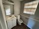 Half bathroom with a white vanity, toilet, and wood-look flooring at 801 Plainville Sw Ter, Atlanta, GA 30331