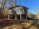 Back exterior of a two-story gray and brick home with trees and fallen leaves on the ground at 801 Plainville Sw Ter, Atlanta, GA 30331