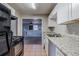 Galley kitchen with white cabinets and view to living room at 231 Glenrose Sw Cir, Atlanta, GA 30354