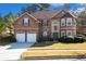 Two-story house with stone accents, two-car garage, and landscaped lawn at 710 Trumpeter Ct, Fairburn, GA 30213