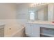 Bright bathroom features a soaking tub, vanity with storage, and large mirror at 3010 Reynolds Run, Mcdonough, GA 30252