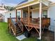 Covered back porch with wooden deck, ceiling fan, and access to backyard at 1927 Streamlet Xing, Kennesaw, GA 30152