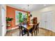 Bright dining room with a wood table and orange accent wall at 1927 Streamlet Xing, Kennesaw, GA 30152