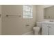 Bathroom with white vanity, toilet, and a window at 6103 Oakwood Sw Cir, Covington, GA 30014