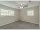 Well-lit bedroom with ceiling fan, neutral walls, and carpet flooring at 6103 Oakwood Sw Cir, Covington, GA 30014