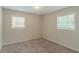 Spacious bedroom with neutral walls, carpet flooring, and two windows at 6103 Oakwood Sw Cir, Covington, GA 30014