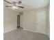 Bright bedroom with ceiling fan, neutral walls and carpet flooring, and a door to the hallway at 6103 Oakwood Sw Cir, Covington, GA 30014