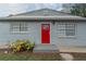 Front entrance with a red door and gray brick facade at 6103 Oakwood Sw Cir, Covington, GA 30014