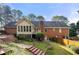 Brick house with sunroom and deck, steps leading to a landscaped yard at 3978 Pate Rd, Loganville, GA 30052