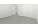 Bright bedroom with grey carpet, double closets, and an additional door at 7370 Gossamer St, Union City, GA 30291