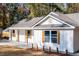 White farmhouse exterior with wood accents, gray roof, and landscaping at 413 Cranfill Se Rd, Marietta, GA 30060