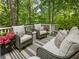 Relaxing deck with wicker furniture and striped rug, offering wooded views at 20 Pointe Se Ter, Atlanta, GA 30339