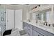 Modern bathroom featuring double vanities, glass shower, and marble-like tile at 6705 Brookline Ct, Cumming, GA 30040