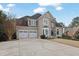 Traditional two-story home with stone accents, three-car garage, and a large driveway at 6705 Brookline Ct, Cumming, GA 30040