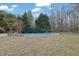 Spacious backyard with an inviting in-ground pool, surrounded by lush greenery and a play area at 6705 Brookline Ct, Cumming, GA 30040