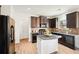 Modern kitchen with dark cabinetry, granite island, and stainless steel appliances at 4655 Cabrini Pl, Cumming, GA 30028