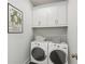 Laundry room with washer, dryer, and overhead cabinets at 108 Cottage Gate Ln, Roswell, GA 30076