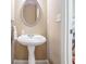 Powder room with pedestal sink and oval mirror at 169 Blue Creek Ln, Loganville, GA 30052