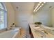 Bathroom with double vanity, large mirror, and garden tub at 2075 Pine Tree Dr # A4, Buford, GA 30518