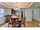 Bright dining room with hardwood floors and chandelier, open to kitchen at 2075 Pine Tree Dr # A4, Buford, GA 30518