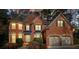 Brick two-story house with two-car garage at dusk at 12175 Clairmeade Trl, Alpharetta, GA 30009