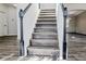 Modern staircase with gray wood-look risers and white railing at 7351 Poppy Way, Union City, GA 30291