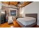 Spacious bedroom with exposed brick wall, hardwood floors, and a chaise lounge at 490 Marietta St # 307, Atlanta, GA 30313