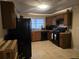 Kitchen with dark wood cabinets and black appliances at 5910 Lakeshore Se Dr, Mableton, GA 30126