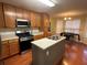 Kitchen with island, stainless steel appliances, and wood cabinets at 5393 S Crest Ridge Dr, Ellenwood, GA 30294