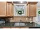 Kitchen sink with granite countertop and brown tile backsplash at 1058 Magnolia Dr, Villa Rica, GA 30180