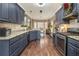 Modern kitchen with granite countertops, stainless steel appliances, and dark blue cabinets at 1008 Ashfern Walk, Woodstock, GA 30189