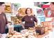 Personal standing behind a bakery stand at an outdoor market at 280 Briscoe Way # 38, Alpharetta, GA 30009