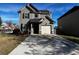 Two-story house with gray siding, a white garage door, and a well-maintained lawn at 6599 Woodwell Dr, Union City, GA 30291