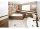 Bathroom with corner bathtub and stone feature wall at 5075 Winters Chapel Rd, Atlanta, GA 30360