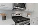 Stainless steel gas range with white cabinets and herringbone backsplash at 2427 Dolce Rd, Dacula, GA 30019