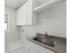 Bright laundry room with white cabinets and a large utility sink at 4002 Moody Ln, Woodstock, GA 30188
