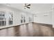 Large living room with hardwood floors, doors to balcony, and ceiling fan at 4002 Moody Ln, Woodstock, GA 30188