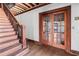 Image shows an entryway with hardwood floors, wooden staircase, and double wood doors at 1225 Clifton Rd, Atlanta, GA 30307