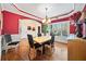 Formal dining room with hardwood floors, red walls, and a chandelier at 4345 Chesterfield Ct, Buford, GA 30518