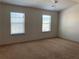 Spacious bedroom with neutral carpeting and two windows at 5671 Radford Loop, Fairburn, GA 30213