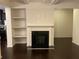 Living room fireplace with built-in shelving and dark hardwood floors at 5671 Radford Loop, Fairburn, GA 30213