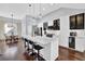 Modern kitchen with white cabinets, quartz countertops, and island seating at 1413 Wilkes Crest Ct, Dacula, GA 30019