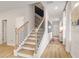 Modern staircase with light wood treads and dark metal railing at 204 Sanctuary Dr # 66, Mcdonough, GA 30253